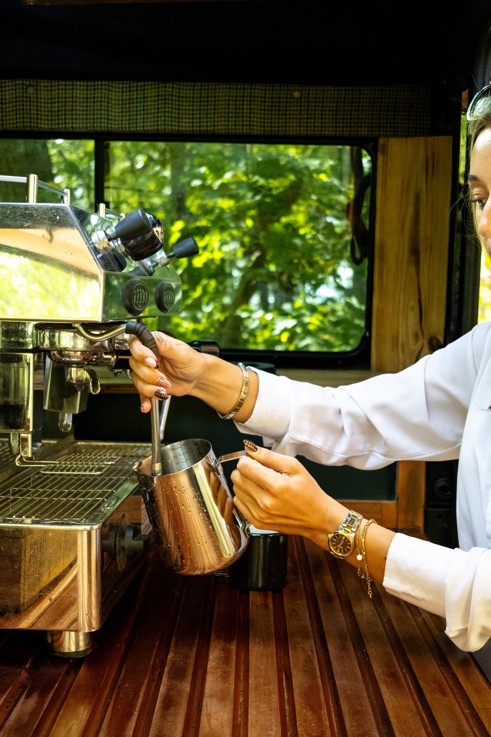 A barista steaming milk at the espresso machine inside the Defender