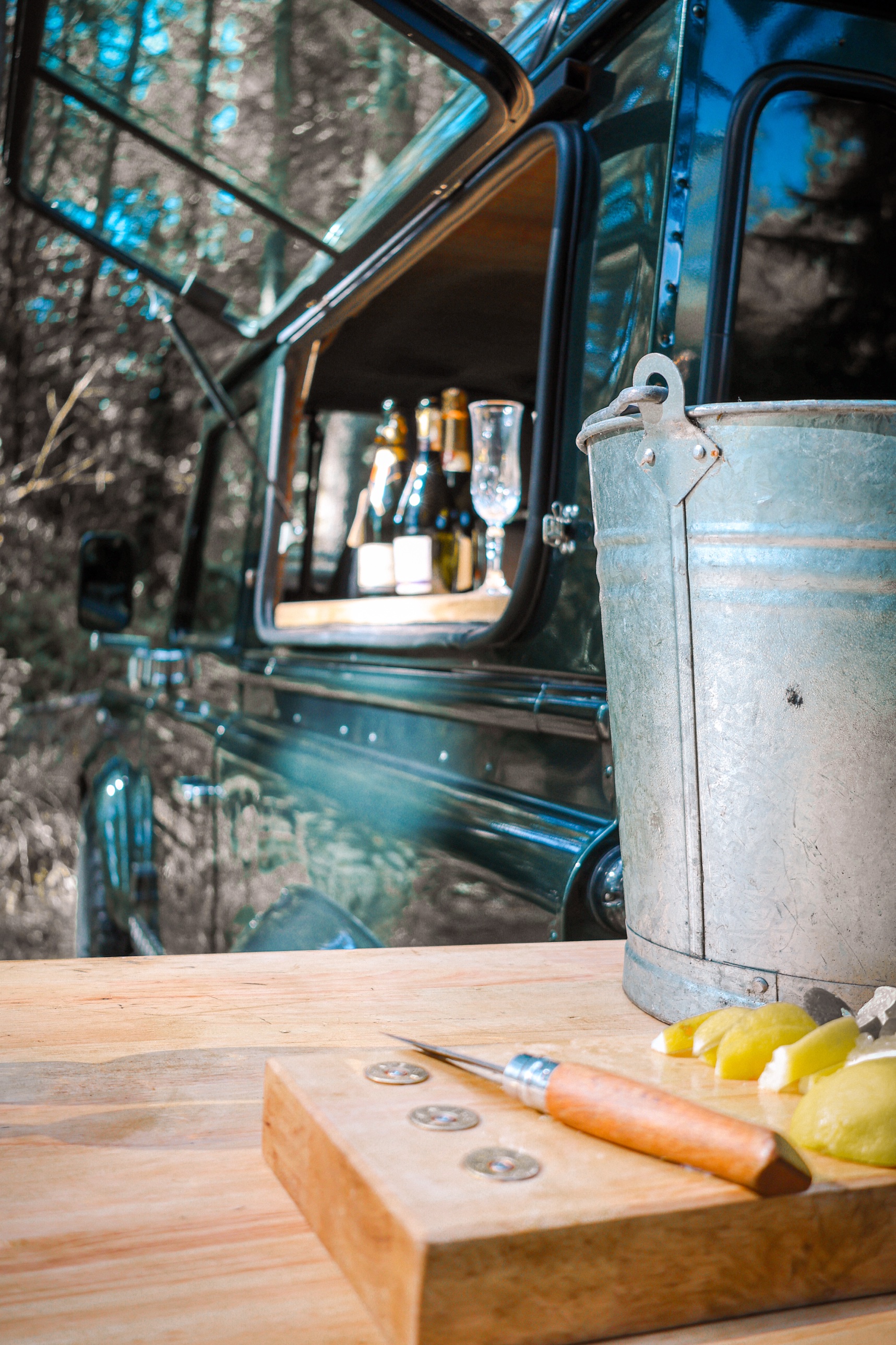 Ice bucket and citrus on the oak counter, with the Defender 90's bar hatch open behind